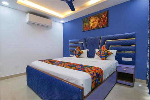 1 dormitorio azul con 1 cama en una habitación en FabHotel Satyam International, en Noida