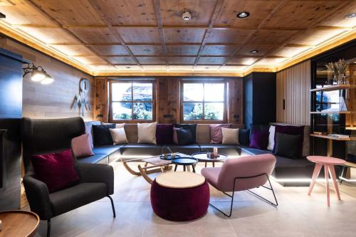 a living room with a couch and chairs and tables at "Quality Hosts Arlberg" Hotel zur Pfeffermühle in Sankt Anton am Arlberg