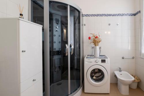 a bathroom with a washing machine and a toilet at GetTheKey Monari Studio in Bologna