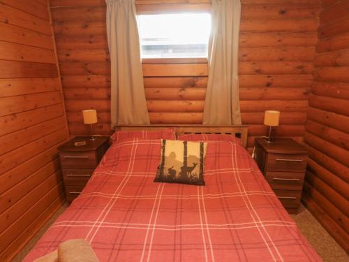 a bedroom with a bed in a log cabin at Glanton in Morpeth