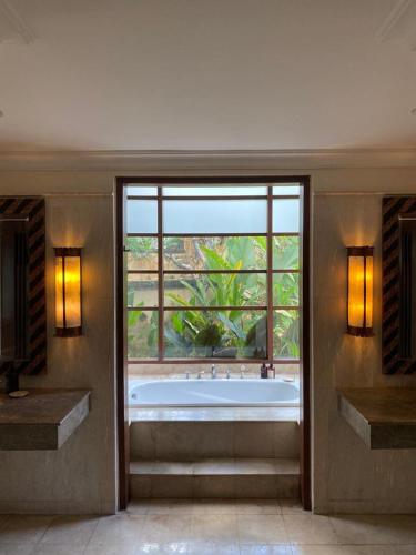 a large bathroom with a tub and a large window at Jimbaran BeachStroll Villa (2BR) in Jimbaran