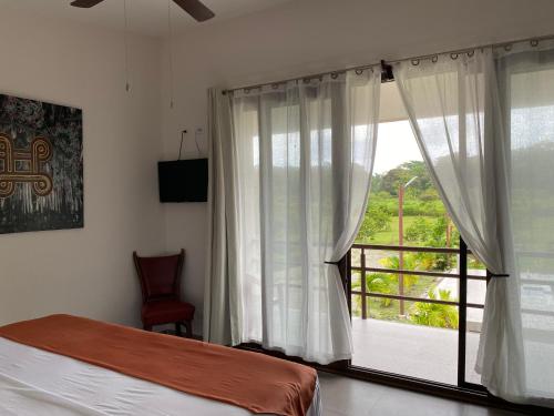 1 dormitorio con cama y ventana grande en Miotrakasa, en Cahuita