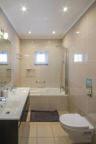a bathroom with a toilet and a tub and a sink at Casa Monte Cristo IV in Lagos