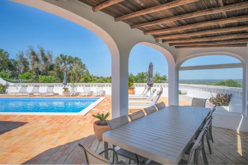 a patio with a table and chairs and a swimming pool at Casa Monte Cristo IV in Lagos
