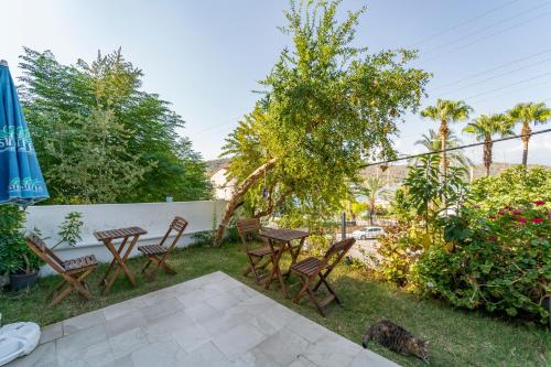a patio with a table and chairs in a yard at Nakas Suites in Fethiye