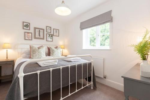 a bedroom with a bed and a window at Oxfordshire Living - The Henrietta Cottage - Woodstock in Woodstock