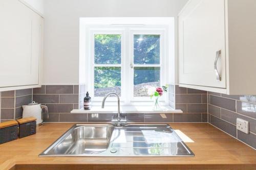 a kitchen with a sink and a window at Oxfordshire Living - The Henrietta Cottage - Woodstock in Woodstock