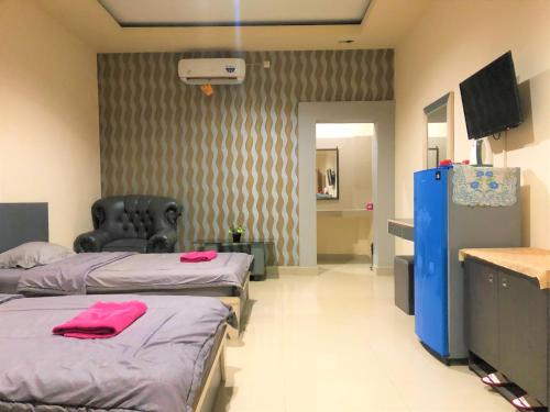 ein Krankenhauszimmer mit 2 Betten und einem TV in der Unterkunft MS Hotel Pinrang Mitra RedDoorz in Pinrang