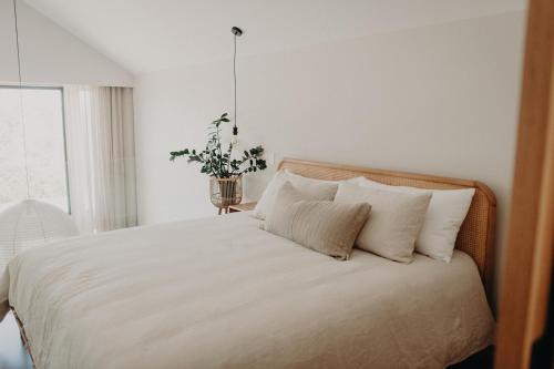 een bed met witte lakens en kussens in een slaapkamer bij View Street Studios - Tallerack in Albany