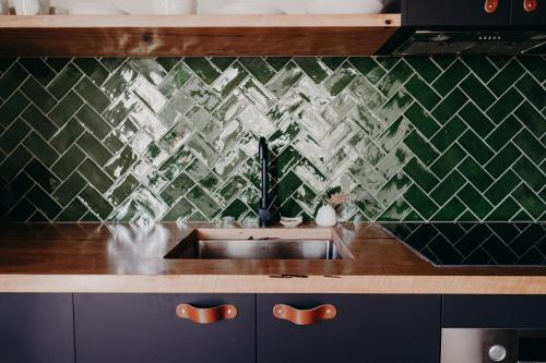 a kitchen with a sink and a green tiled wall at View Street Studios - Tallerack in Albany