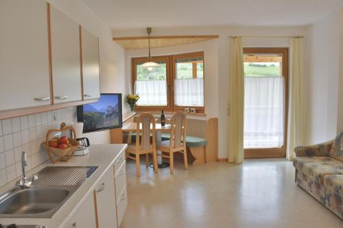 a kitchen and living room with a table and a couch at Residence Feldhof in Kastelbell-Tschars