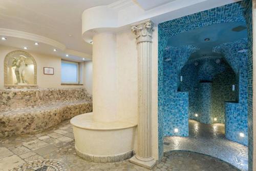 a bathroom with a shower with a blue tiled wall at Alpenhof in Bayrischzell