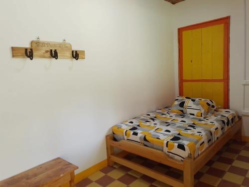 a small bedroom with a bed and a table at Hospedaje Campestre El Rancho de Jero in Jardin
