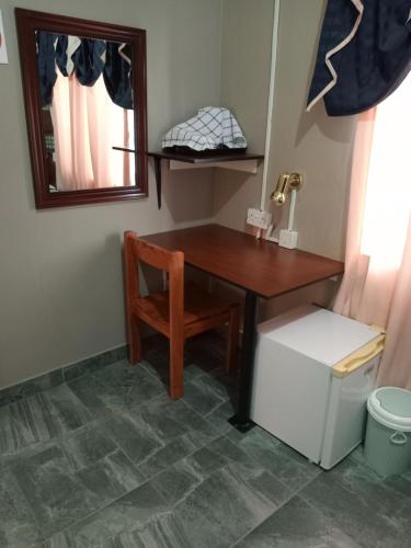 einen Schreibtisch mit einem Stuhl und einem Spiegel in einem Zimmer in der Unterkunft Ledoba Bed & Breakfast 