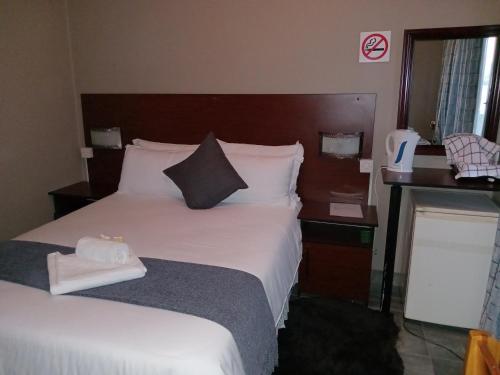 a hotel room with a large bed with white sheets at Ledoba Bed & Breakfast in Molalatau