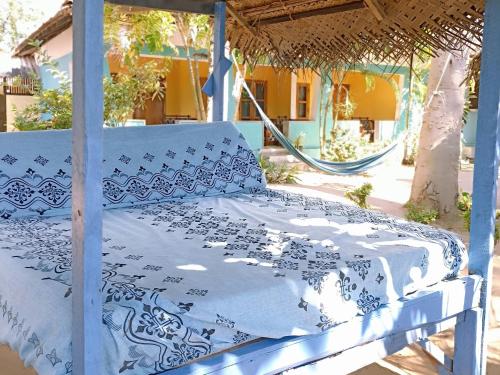 a bed with a blue and white blanket on it at Arne's Place in Arugam Bay