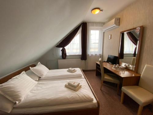 um quarto com uma cama e uma secretária com um espelho em Penzión Tiberia em Trenčín