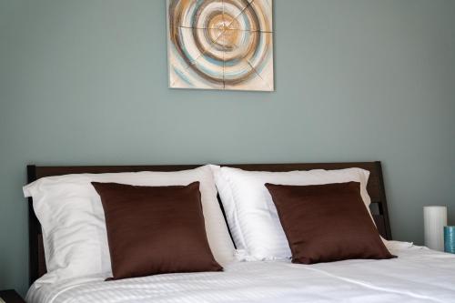 a bed with two pillows and a picture on the wall at Sea View Volos in Volos