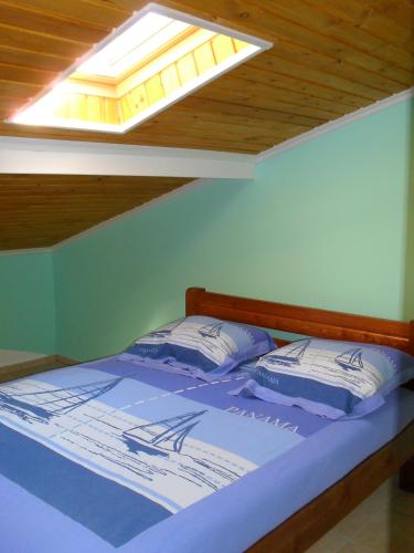 a bedroom with a bed with a skylight at la villa de Rose in Kalymnos