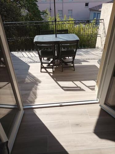 een patio met een tafel en stoelen op een balkon bij Studio meublé climatisé avec terrasse in Draguignan
