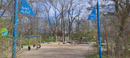 un parque infantil en un parque con carteles de la calle azul en Ferienhaus am Auensee en Leipzig