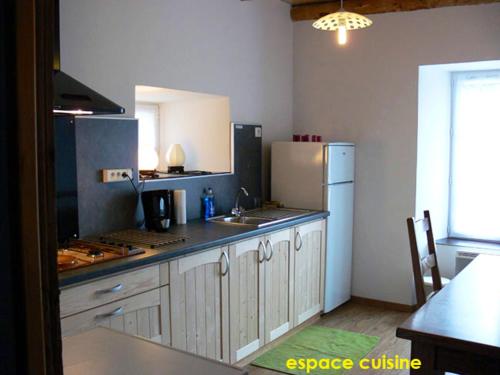 une cuisine avec un réfrigérateur blanc et un évier dans l'établissement Maison de charme en campagne à Arlempdes avec jardin, à Arlempdes