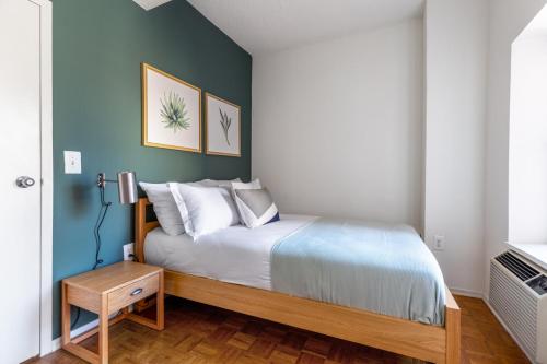 a bedroom with a bed with a blue wall at Chelsea 1BR w Gym Concierge nr Penn Stn MSG NYC-439 in New York