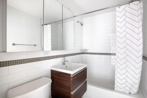 a white bathroom with a sink and a toilet at Chelsea 1BR w Gym Concierge nr Penn Stn MSG NYC-439 in New York