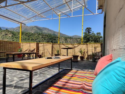 a patio with a table and a view of mountains at Proto Hostel in Chamba