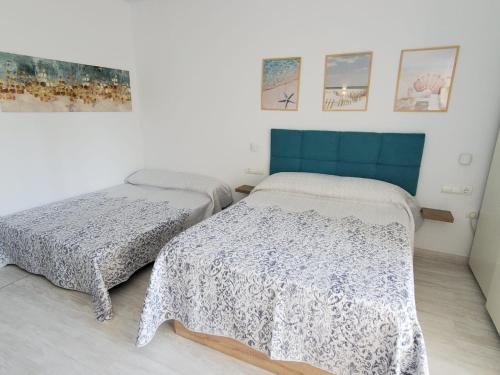 a bedroom with two beds and a blue headboard at Benal Beach 229 in Benalmádena