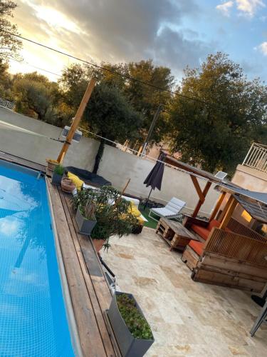 une arrière-cour avec une piscine et une terrasse avec des chaises dans l'établissement VILLA 6 PERSONNES /PISCINE/CAMPAGNE/TERRAIN DE PETANQUE/15 km BANDOL, au Beausset