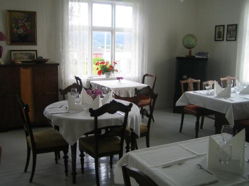 un comedor con mesas y sillas blancas y una ventana en Skagakaia, en Bø i Vesterålen