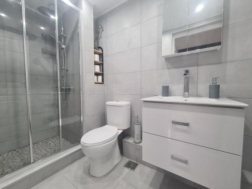a white bathroom with a toilet and a shower at Pindarou Apartment in Nicosia