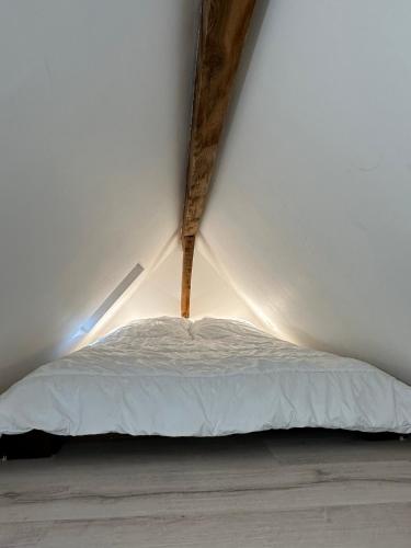 a white bed in a room with a ceiling at Superbe appartement mansardé avec mezzanine - proche centre ville, thermes, aquensis in Bagnères-de-Bigorre