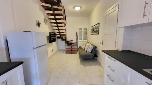 a kitchen with a white refrigerator and a stairway at Villetta Eliselena Best Vacation Ever in Villasimius