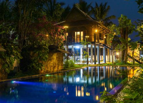 a house with a swimming pool in front of a house at SOK VILLA by Angkorstays in Siem Reap