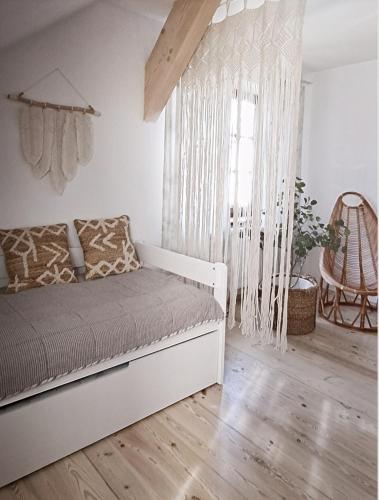 a bedroom with a bed and a window with curtains at FORMA Apartament Supraśl in Supraśl