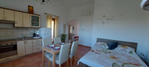 eine Küche mit einem Bett und einem Tisch mit Stühlen in der Unterkunft WineHouse with Seaview Gregoric in Izola