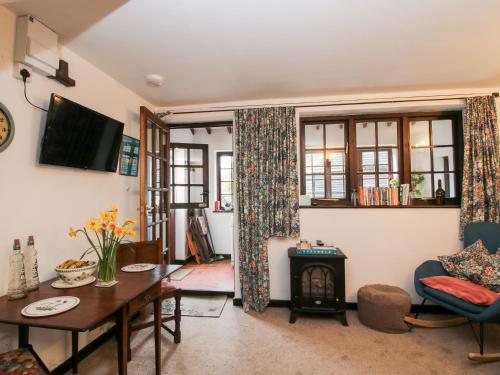 a living room with a table and a wood stove at The Wheelhouse at Dudgeley Mill in Church Stretton