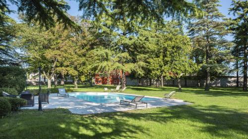 una piscina in un cortile con sedie e alberi di Villa Chiopris a Chiópris-Viscone