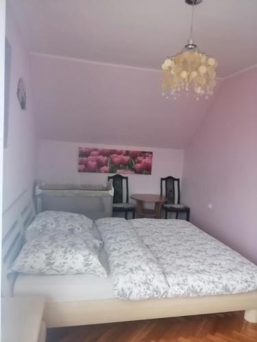 a white bed in a room with a chandelier at villa in Nowa Ruda