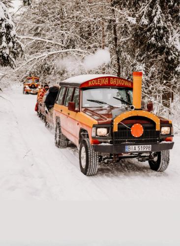 an orange truck is parked in the snow at FORMA Apartament Supraśl in Supraśl
