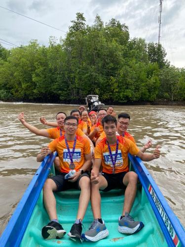 a group of men sitting on a raft on a river at Homestay Hải Nam Đất Mũi in Xóm Mũi