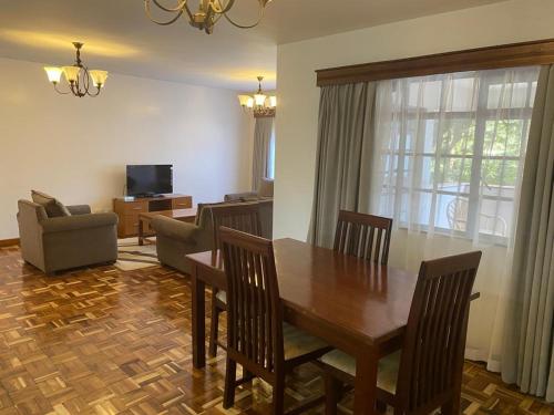 內羅畢的住宿－Capital Apartments- Hendred Road，客厅设有餐桌和沙发