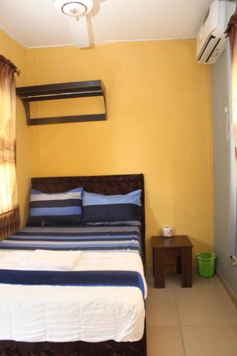 1 dormitorio con cama y pared amarilla en JOEL'S HOTELS & SUITES, en Ikeja