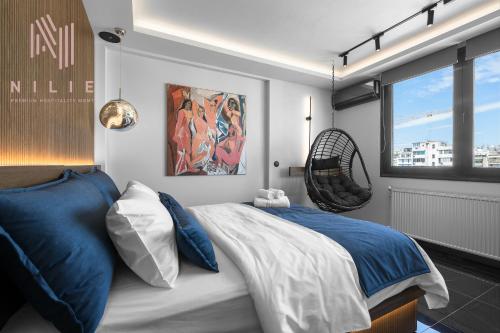 - une chambre dotée d'un grand lit avec des oreillers bleus et blancs dans l'établissement Calliope Penthouse, Nilie Hospitality MGMT, à Thessalonique