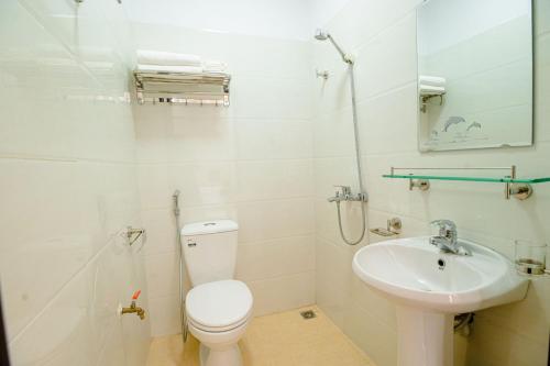 een witte badkamer met een toilet en een wastafel bij Hồng Ngọc Hotel in Lạng Sơn