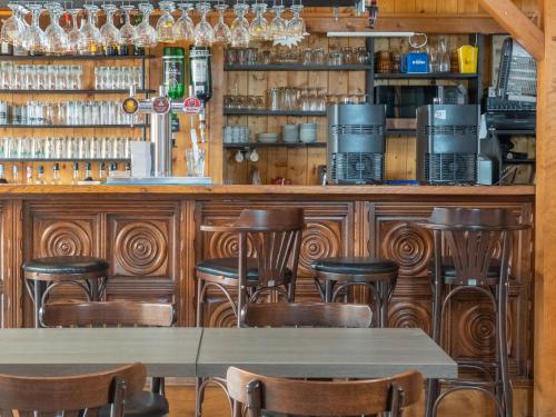 un bar avec une table et des chaises dans un restaurant dans l'établissement Camping les 3 Sablières, à Saint-Firmin