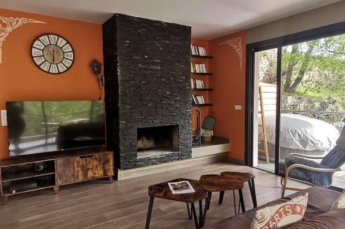 a living room with a fireplace and a tv at Maison avec jacuzzi au cœur des montagnes in Feliceto