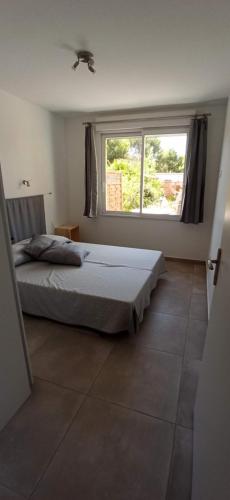 een slaapkamer met een bed en een groot raam bij Les Gites De La Pinede in Balaruc-les-Bains